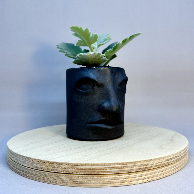 A tall tiki-shaped vessel with a face