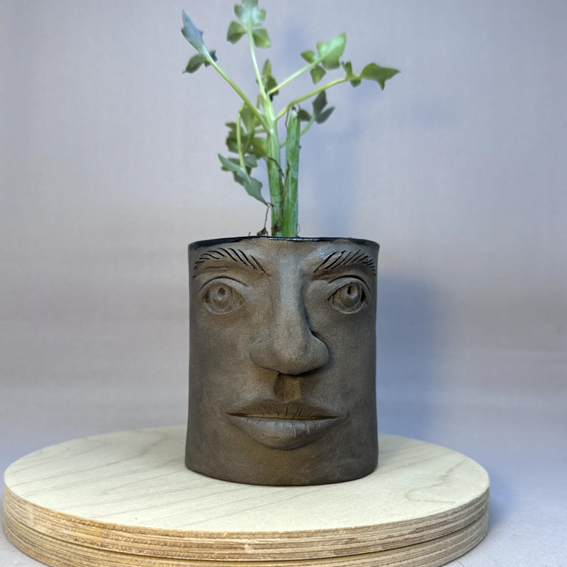 Two cup-shaped vessels with faces