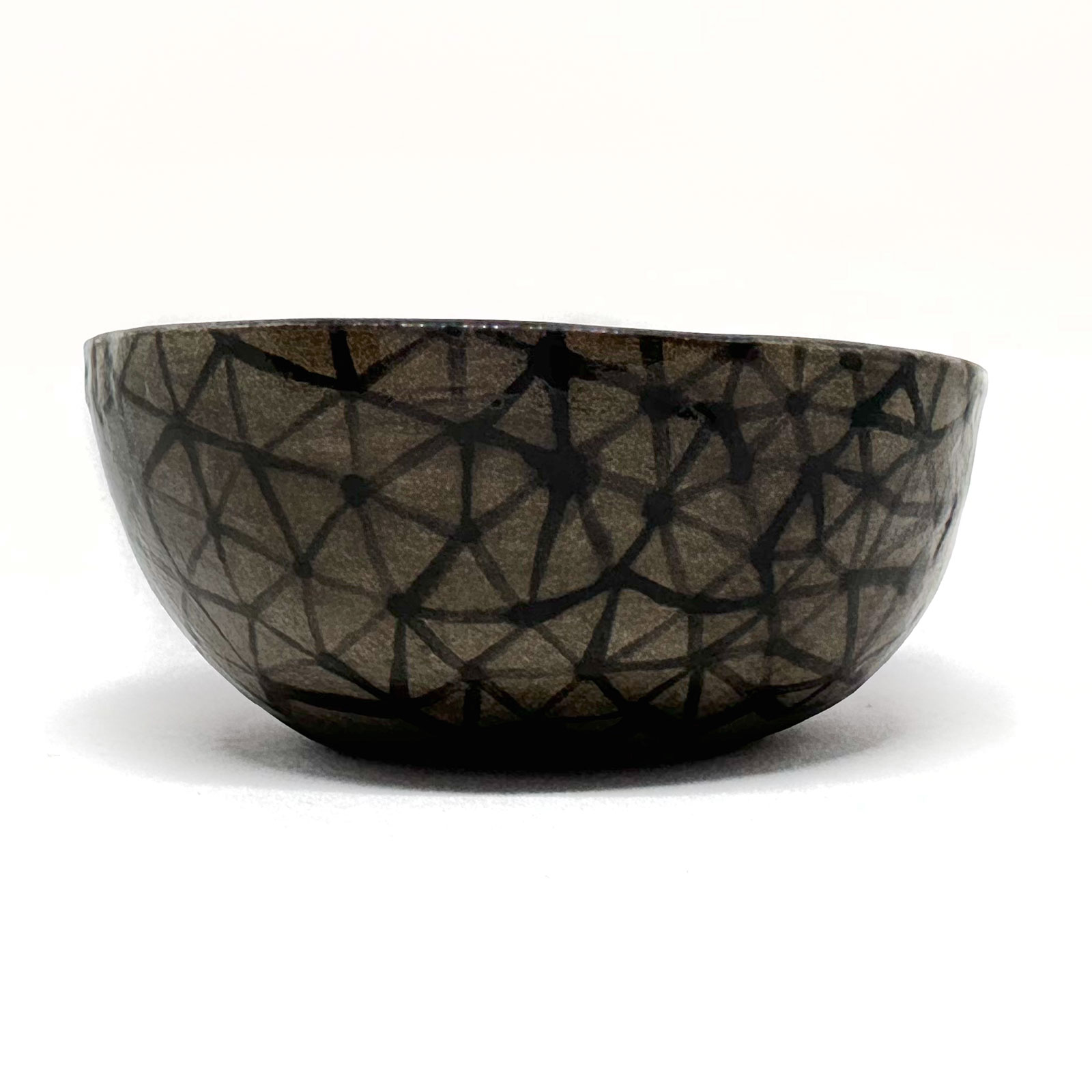 a dark grey ceramic plate with constellation-like patterns glazed in black